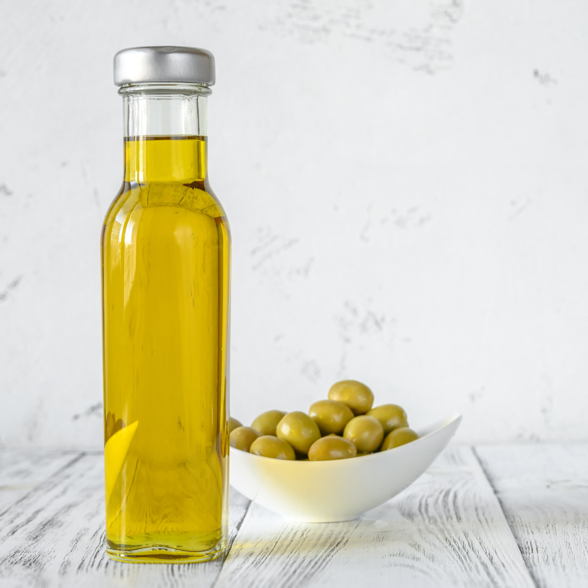 Bottle of olive oil with green olives